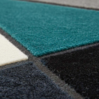 Deep teal area rug with hand tufted plush geometric design and durable poly-blend fibers