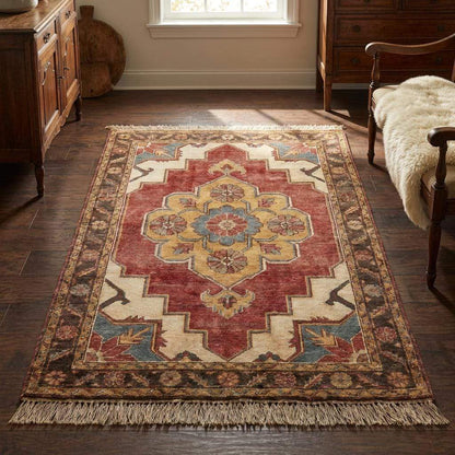 Hand knotted wool area rug with floral medallion design in brick red, ivory, and gold tones