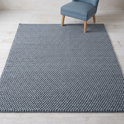 Chunky Wool Rug in slate blue-gray wool-style fiber, with a thick handwoven surface of tightly spaced rounded pebble texture.