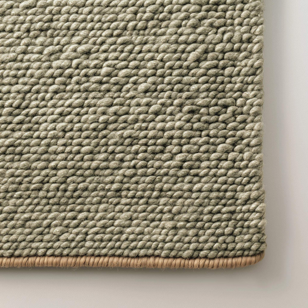 Green chunky wool rug with handwoven pebble texture in natural sage tone