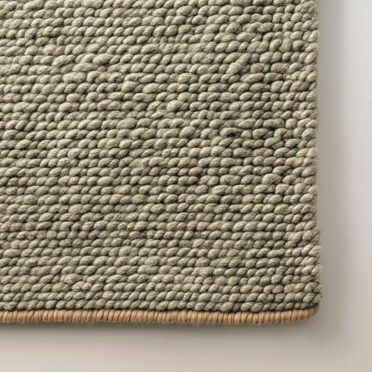 Green chunky wool rug with handwoven pebble texture in natural sage tone