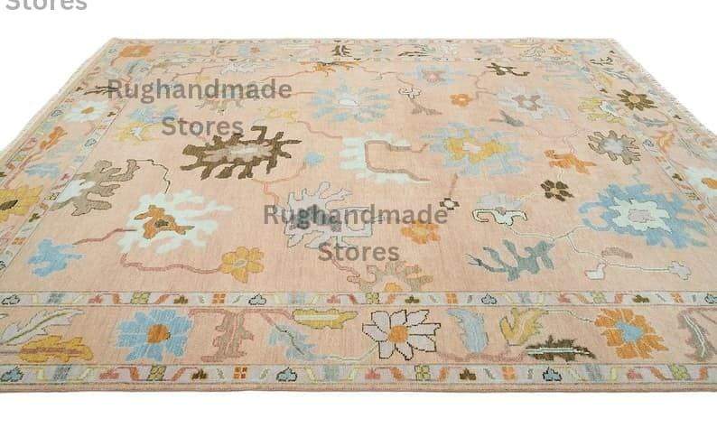 Hand-knotted Oushak wool rug with vintage floral design in light pink, dark brown, and purple accents for living room decor