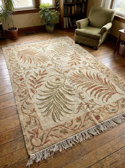 Hand-knotted wool area rug with sage green botanical pattern and natural wool texture