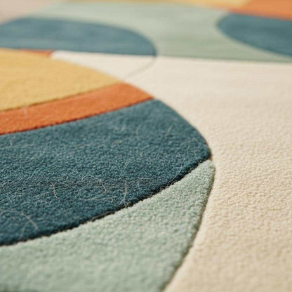 Hand tufted geometric area rug with burnt orange, teal, mustard gold, and sage tones in mid-century modern style