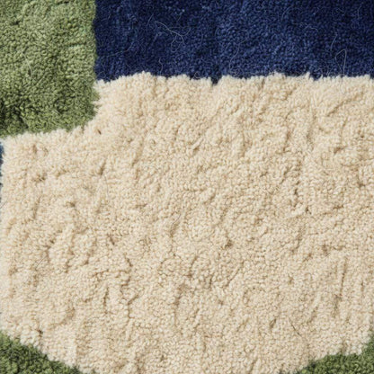 Hand tufted rug with bold blue and green geometric design, soft wool texture, and plush pile for mid-century modern decor