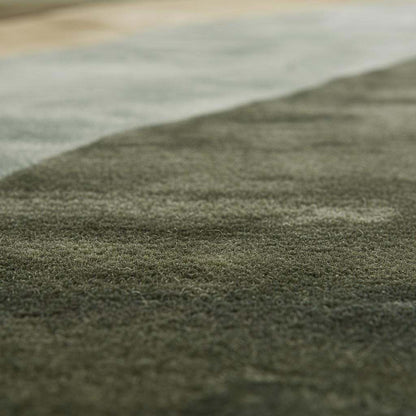 Hand tufted wool rug with abstract landscape design in earthy green tones for modern Scandinavian and Japandi interiors