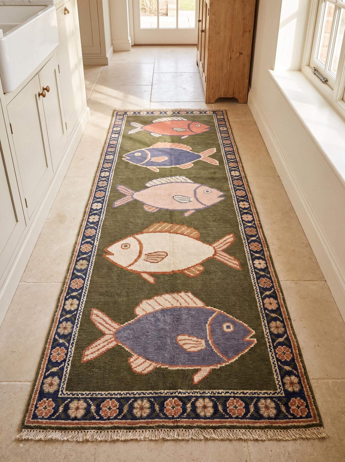 Hand knotted wool fish runner rug with coastal fish motifs and floral border in olive green and navy blue tones for beach house decor