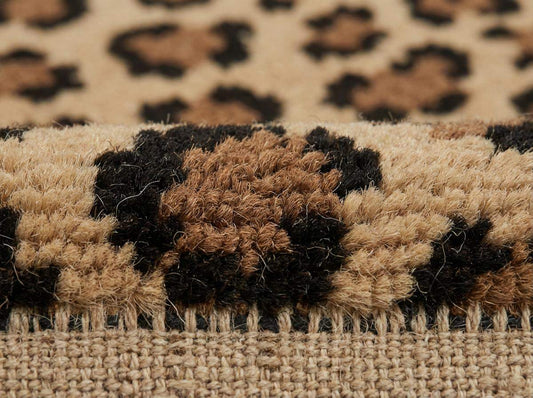Close up of hand knotted wool rug showing dense pile, natural wool fibers, and leopard pattern detail