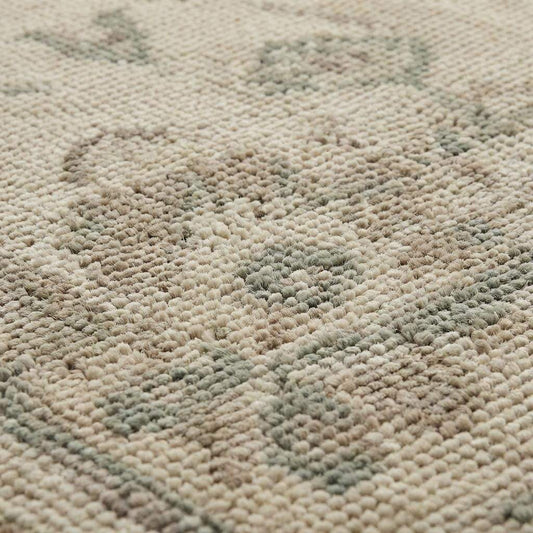 Close up of hand knotted wool rug showing low pile texture and individual knot structure