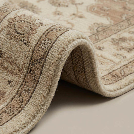 Close up of hand knotted wool pile showing organic texture, individual knots, and soft sheen of natural fibers.