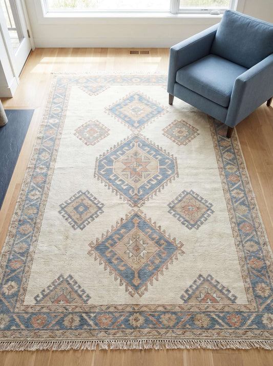 Hand knotted Oushak rug in beige with soft blue geometric tribal patterns placed in modern living room __etsy:7986405671