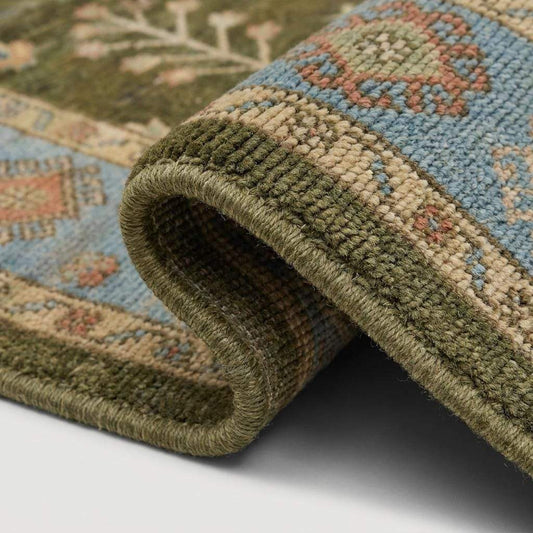 Close-up of hand knotted wool rug showing dense low pile texture, detailed floral motifs, artisan knotting, and natural wool fibers __etsy:8122486855