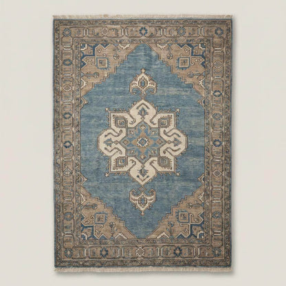 Traditional blue medallion Oushak area rug on wooden floor beside leather armchair and linen curtains