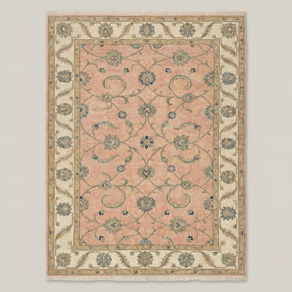 Intricate Turkish floral motifs in sage green and blue on a pastel pink wool rug.