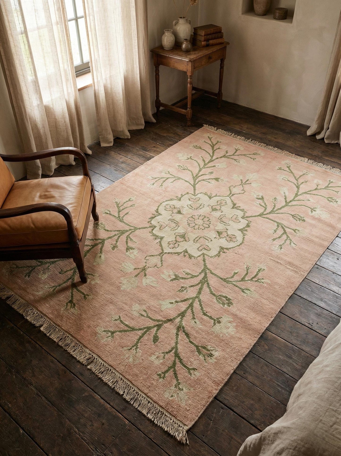 Hand knotted Oushak rug in blush pink wool with floral medallion design in living room