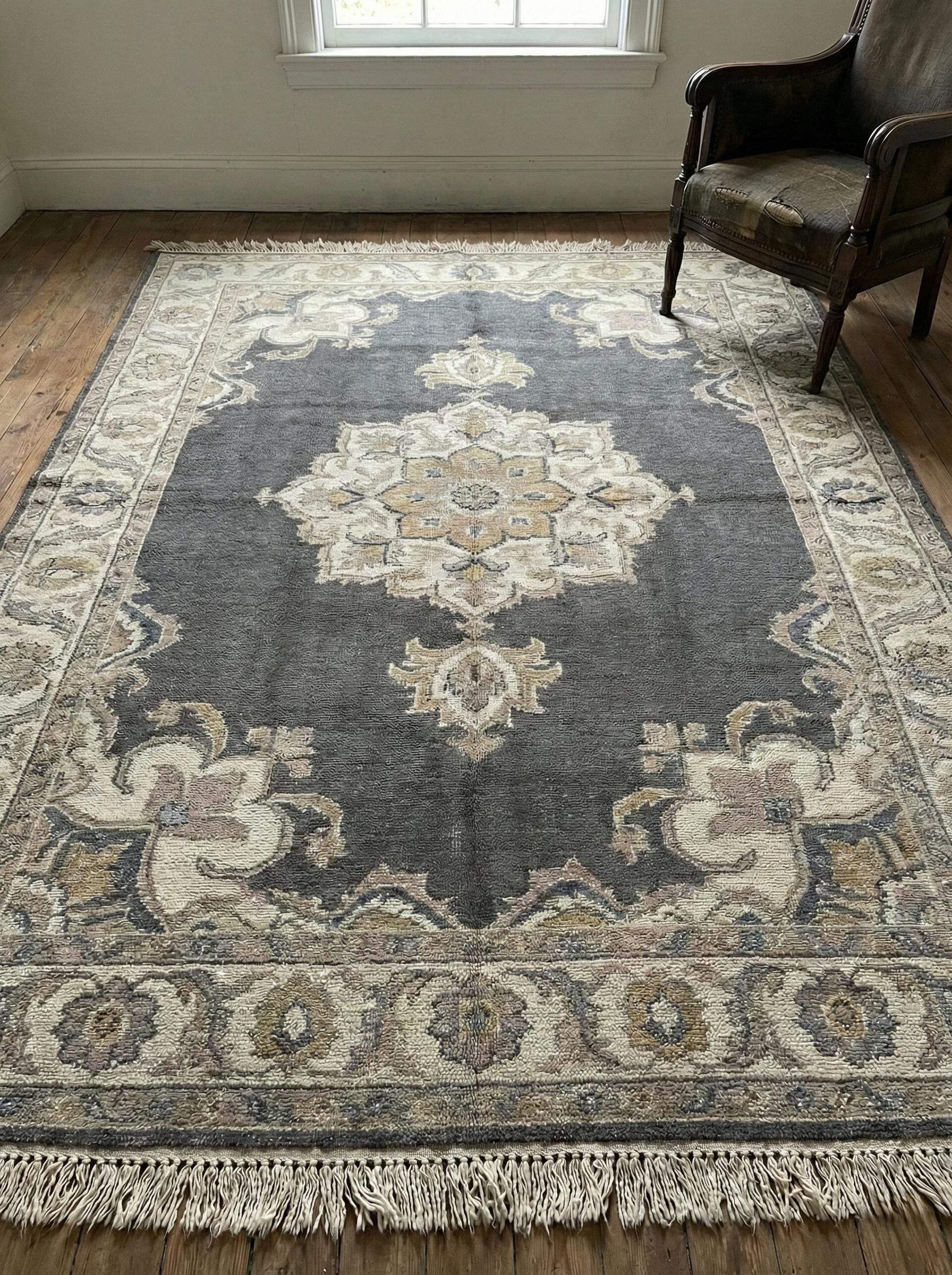 Full view of hand knotted Oushak rug in charcoal grey with cream medallion pattern on wooden floor. __etsy:7693759383