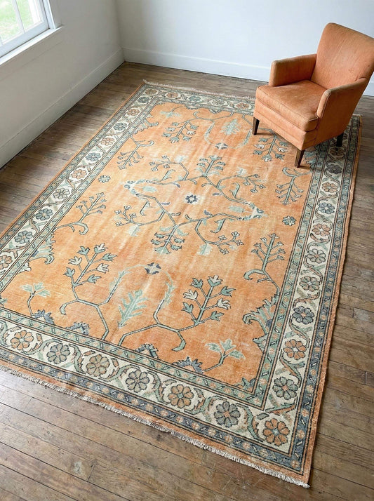 Hand knotted Oushak rug with muted apricot and sage green vintage floral design, handmade wool area rug for boho living room decor
