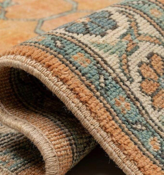 Close up detail of hand knotted wool pile texture showing individual knots and the natural sheen of the hand-spun wool fibers.