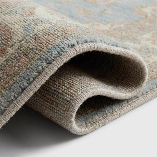 Close up detail of hand knotted wool pile showing individual knots and soft texture without latex backing.