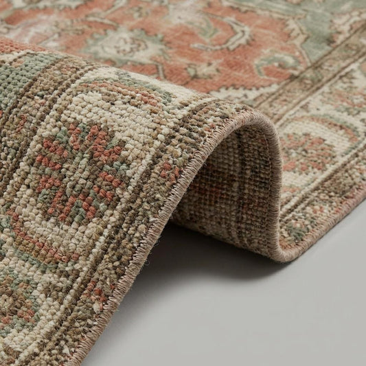 Close up of hand knotted wool pile showing individual knots, distressed texture, and soft sheen of the natural fibers.