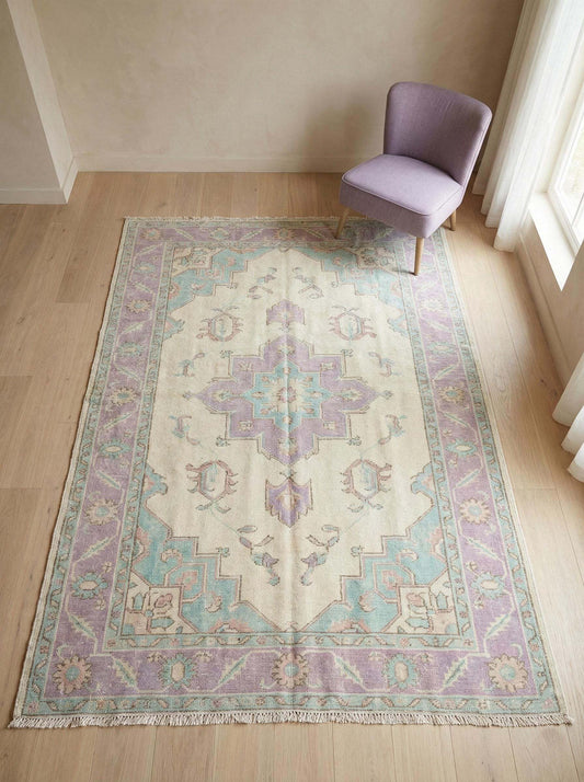 Hand knotted Oushak area rug with pastel lavender medallion design placed in modern living room interior __etsy:7740948760