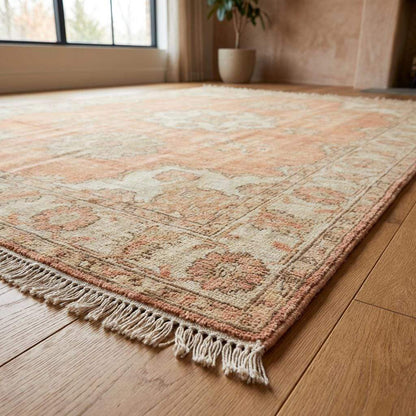 Hand knotted Oushak rug with peach floral medallion and vintage-style fading on natural wool fibers
