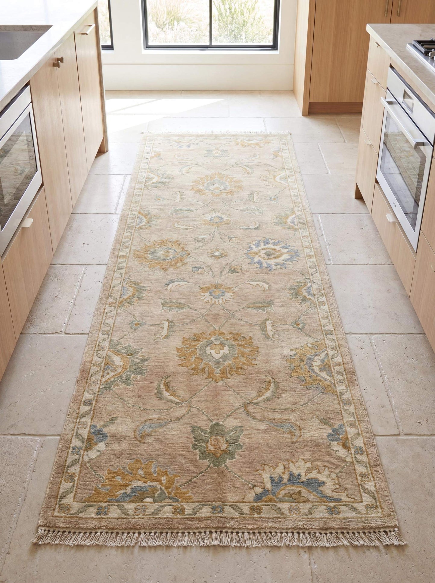 Hand knotted Oushak runner rug with floral motifs in beige, blue, and sage tones styled in a bright modern kitchen hallway __etsy:8091987986