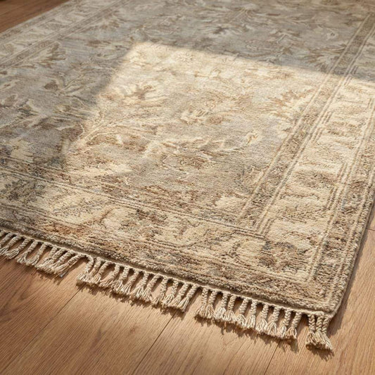 Close-up of dense hand knotted wool pile showing individual knots, natural fiber texture, and subtle tonal variation in beige and taupe