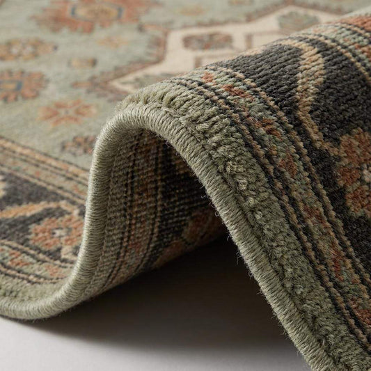 Close-up of hand knotted wool rug showing dense pile, individual knots, and natural wool texture