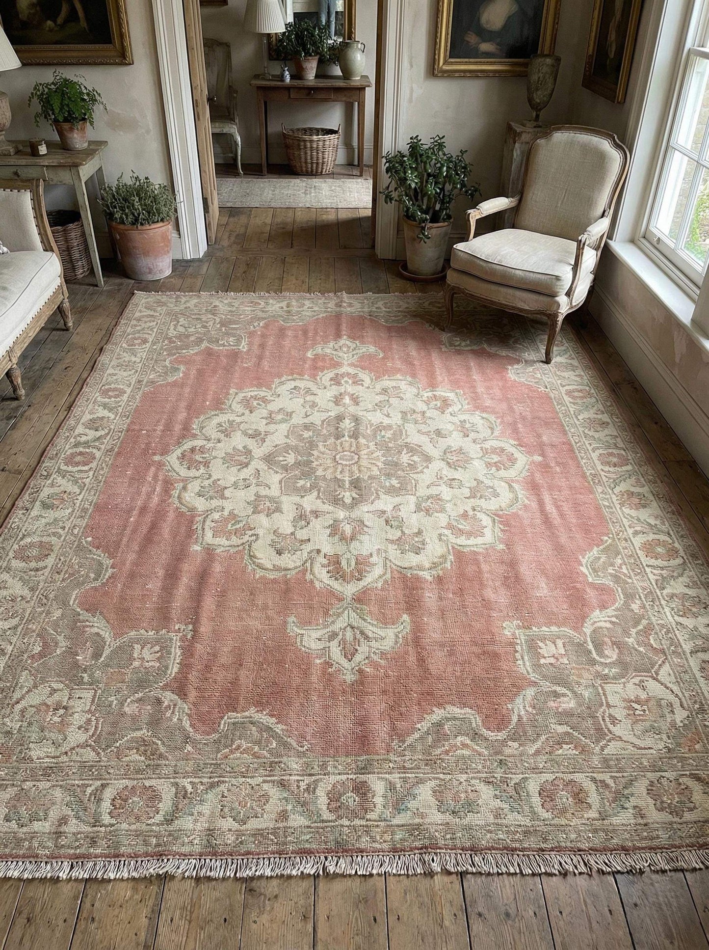 Hand knotted Oushak wool rug with faded pink medallion and vintage patina