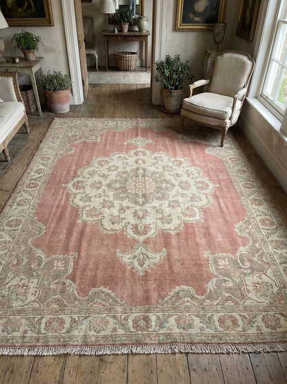 Hand knotted Oushak wool rug with faded pink medallion and vintage patina