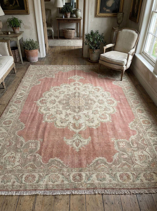 Hand knotted Oushak wool rug with faded pink medallion and vintage patina