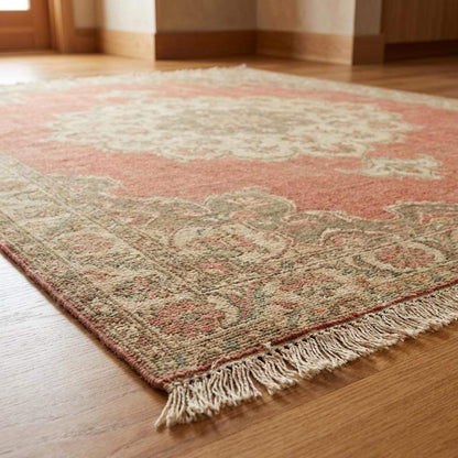 Artisan made wool rug with aged patina and muted pink color palette