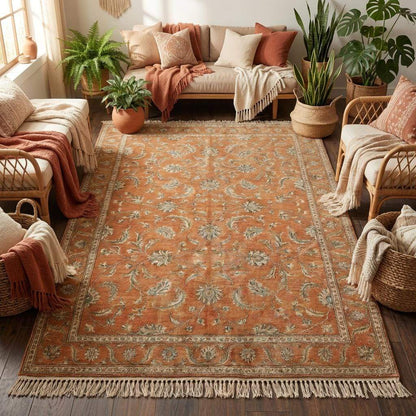 Artisan handmade wool rug in earth tones, featuring a burnt orange field with sage green accents, perfect for organic modern interior design.