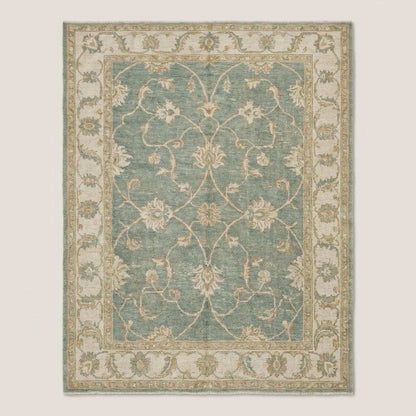 Traditional Oushak area rug with muted green and ivory tones in natural light