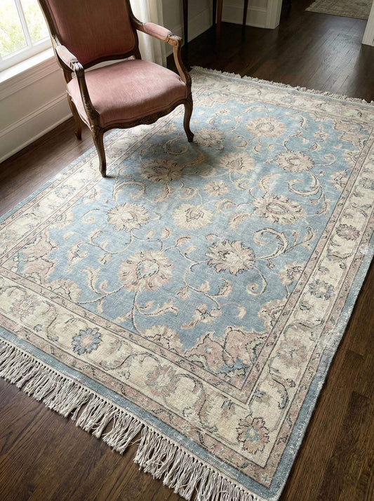 Hand knotted Oushak wool rug with soft blue floral design and natural wool texture