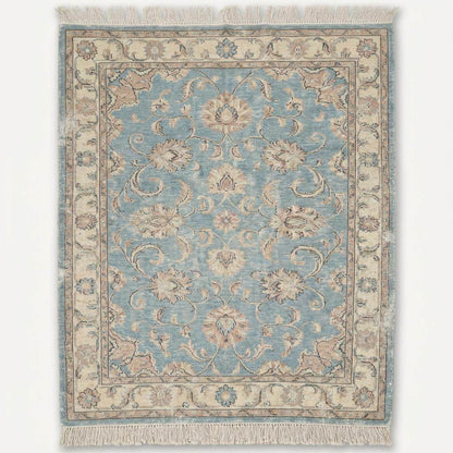 Traditional Oushak style wool rug with light blue field and ivory floral border details