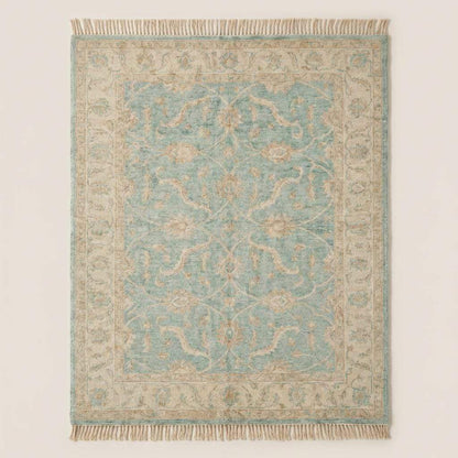 Hand knotted Oushak wool rug with vintage blue floral design in soft neutral living room setting