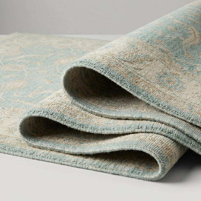 Hand knotted Oushak wool rug with vintage blue floral design in soft neutral living room setting
