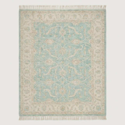 Hand knotted Oushak wool rug with vintage blue floral design in a soft neutral living room setting
