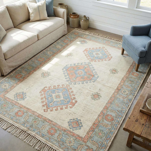 Hand knotted Oushak wool rug in ivory and muted blue with geometric medallion pattern styled in a bright living room __etsy:7778994455