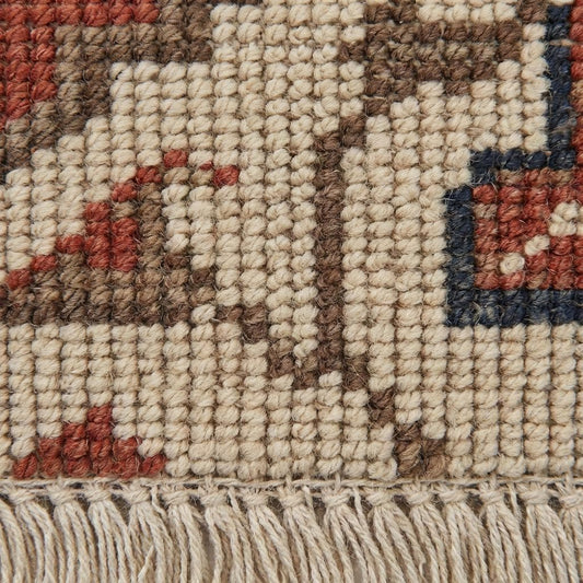 Close-up of hand knotted wool pile showing individual knot texture and natural fibers