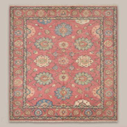 Vintage Turkish style pink area rug with blue floral accents and decorative border on hardwood flooring __etsy:8119356277