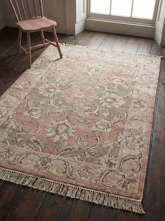 Hand knotted wool rug in muted pink and beige with vintage floral design for bedroom or living room decor