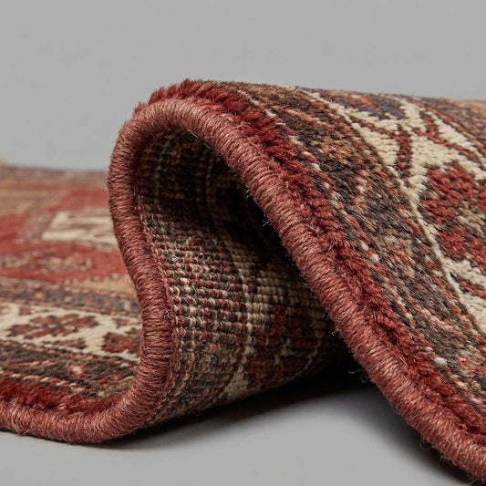 Close up of hand knotted wool pile showing individual knots, natural wool fibers, and artisan craftsmanship
