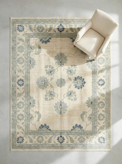 Hand knotted wool Oushak rug with muted blue floral design and vintage botanical motifs