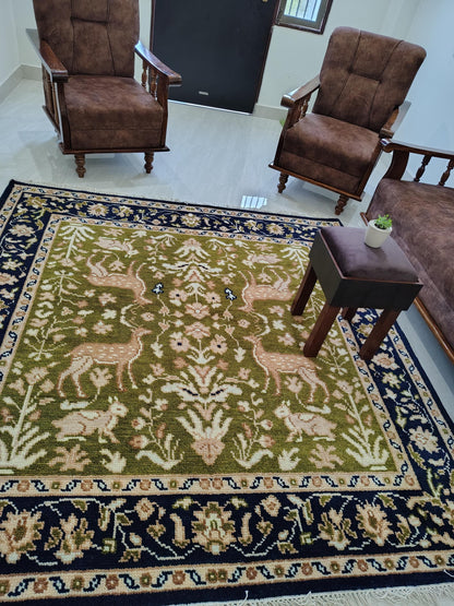 Hand knotted wool rug with Persian animal motif and navy floral border on green field
