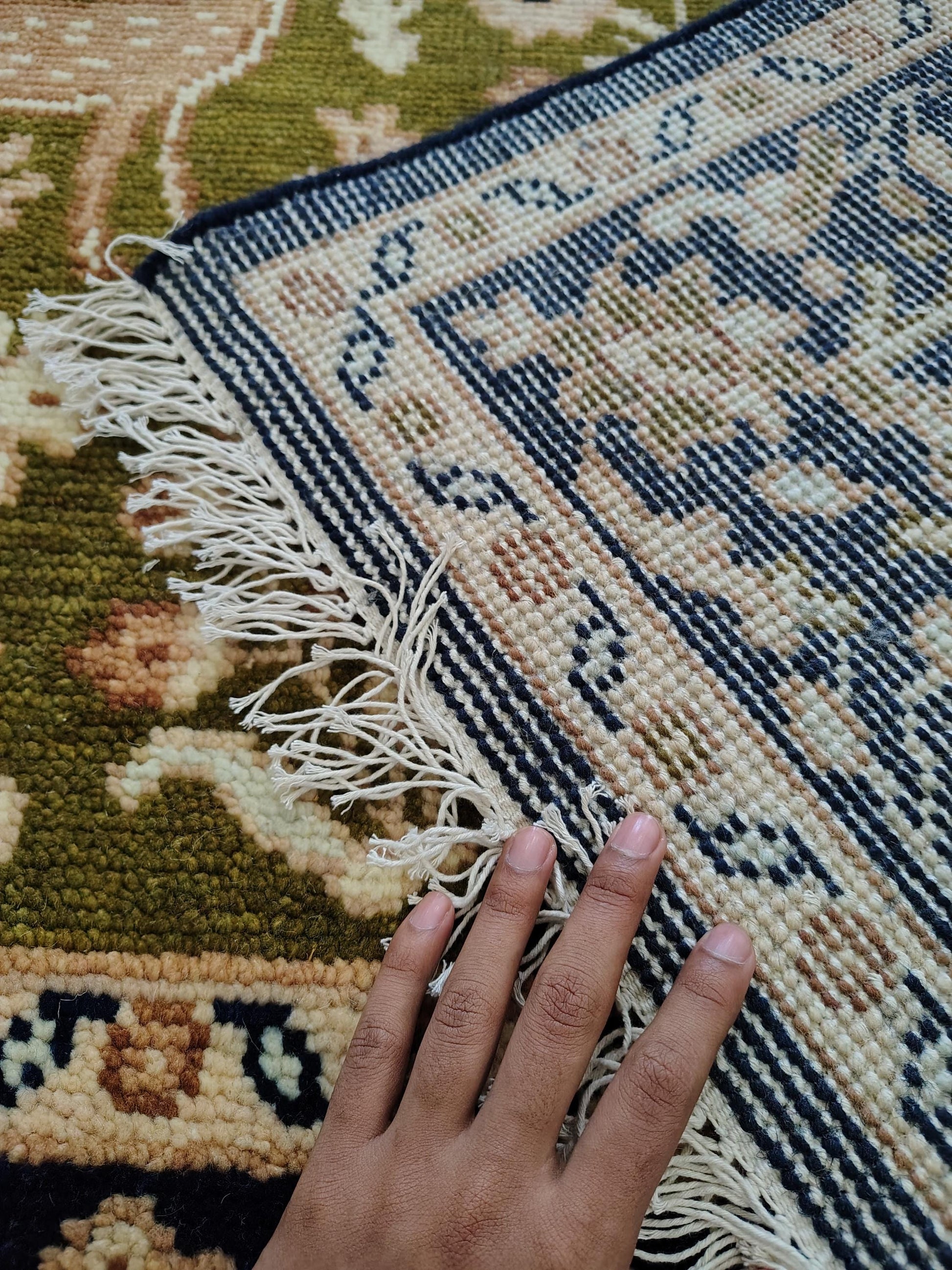 Hand knotted wool rug with green Persian animal motif and navy floral border