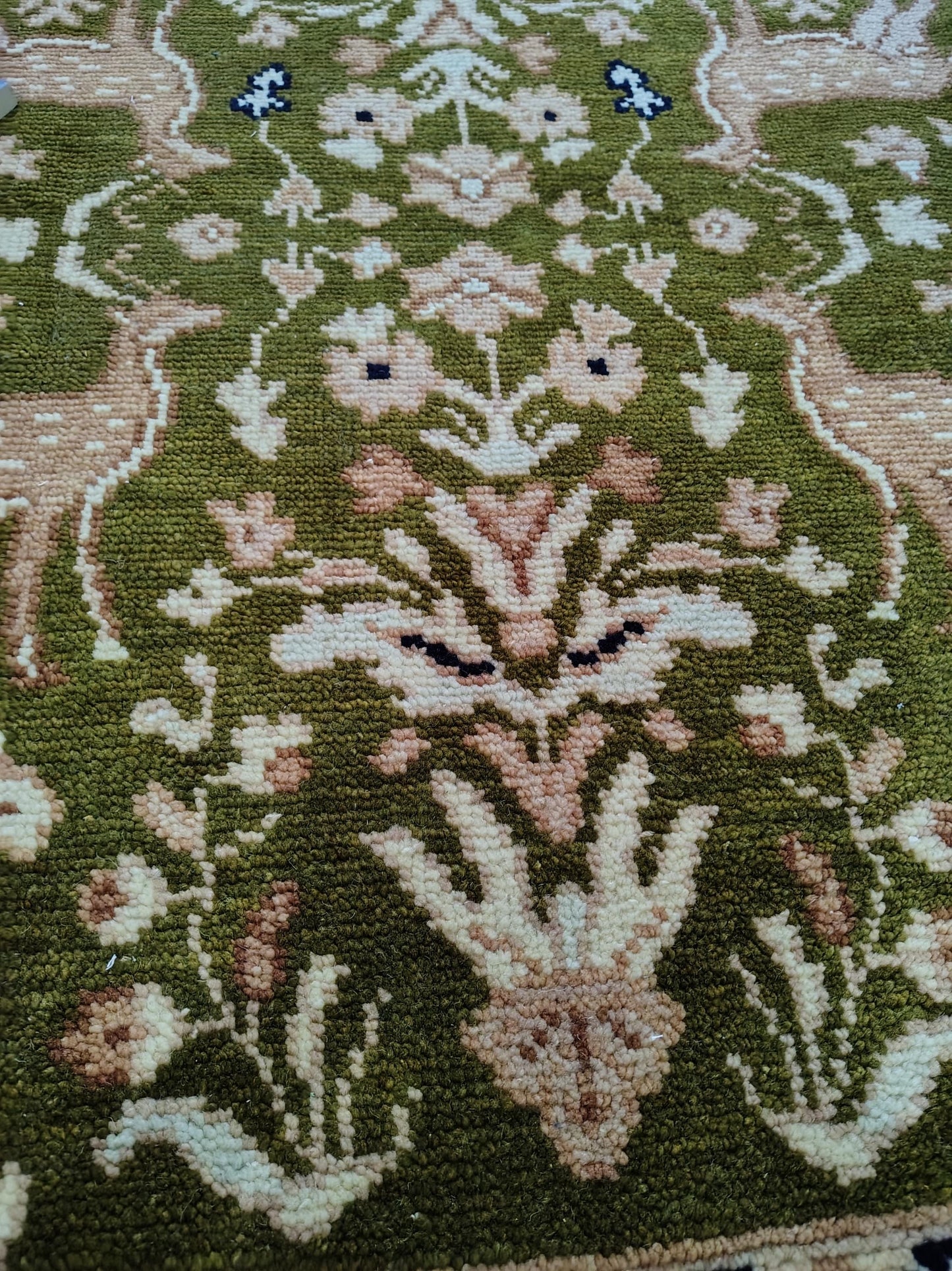 Hand knotted wool rug with green Persian animal motifs and navy floral border