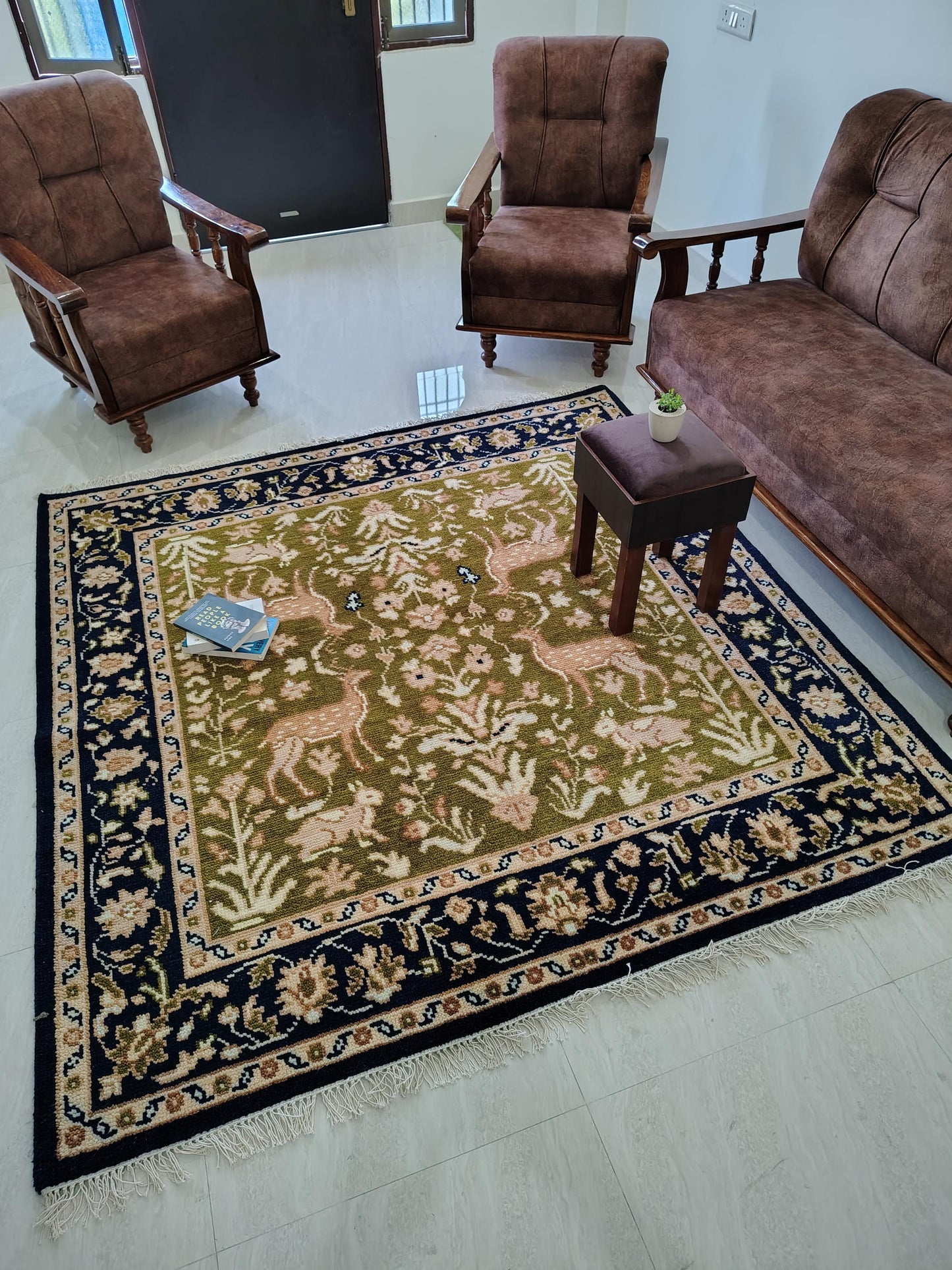 Hand knotted wool rug with Persian animal motifs, green field, navy floral border, traditional living room carpet